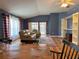 The living area features hardwood floors, comfortable seating, a custom built-in shelving unit, and a view of the dining area at 18109 Webster Grove Dr, Hudson, FL 34667