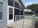 Patio featuring a screened-in sunroom and railing around the outside at 18109 Webster Grove Dr, Hudson, FL 34667