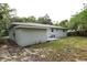 Back exterior of home with sliding glass door, patio and large grassy backyard at 18838 Rosephil St, Spring Hill, FL 34610