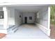 Spacious covered carport with concrete floor and access door, freshly painted in neutral tones at 18838 Rosephil St, Spring Hill, FL 34610