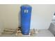 Utility room featuring a large blue water pressure tank and white pipes at 18838 Rosephil St, Spring Hill, FL 34610