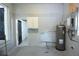 Utility room with a water heater, gray walls and a gray epoxy floor at 18838 Rosephil St, Spring Hill, FL 34610