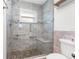 Luxurious walk-in shower features stone flooring, glass door, and tiled bench seating at 2192 Meredith Dr, Spring Hill, FL 34608