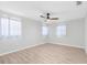 A serene bedroom, features a ceiling fan, three large windows and vinyl floors at 2192 Meredith Dr, Spring Hill, FL 34608