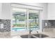 Granite counters and tiled backsplash accent the stainless sink with a pool view at 2192 Meredith Dr, Spring Hill, FL 34608