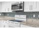 Beautiful white kitchen with granite counters, tiled backsplash and stainless appliances at 2192 Meredith Dr, Spring Hill, FL 34608