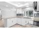 Bright kitchen featuring granite countertops, white cabinetry, and stainless steel appliances at 2192 Meredith Dr, Spring Hill, FL 34608