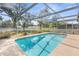 Screened-in pool offers a refreshing retreat with a picturesque view of the backyard at 2192 Meredith Dr, Spring Hill, FL 34608
