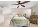 Bedroom with a ceiling fan, neutral carpet, a comfortable chair, and windows with natural light at 2292 Wyndam Dr, Spring Hill, FL 34606