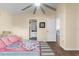 Bright bedroom showcasing wood floors, large ceiling fan, and a view to the bathroom at 261 Rochester St, Spring Hill, FL 34609