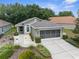 Charming single-story home with well-maintained landscaping, concrete driveway, and screened garage at 261 Rochester St, Spring Hill, FL 34609