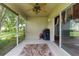 Cozy screened patio featuring an outdoor seating area, grill, and relaxing view at 261 Rochester St, Spring Hill, FL 34609