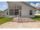 Backyard features a brick paver patio, steps up to the house, manicured lawn, and a view of the sunroom at 284 Quane Ave, Spring Hill, FL 34609