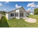 Well-manicured backyard features a brick paver patio and lush green lawn leading to the enclosed sunroom at 284 Quane Ave, Spring Hill, FL 34609
