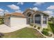 Exterior showcasing the home's attached garage, front door, well-manicured lawn and beautiful landscape at 284 Quane Ave, Spring Hill, FL 34609