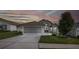 Charming single-story home featuring an attached two-car garage and a well-manicured front lawn at dusk at 284 Quane Ave, Spring Hill, FL 34609