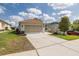 Single-story home showcasing an attached two-car garage, extended driveway, and a well-kept lawn at 284 Quane Ave, Spring Hill, FL 34609