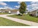 Well-maintained single-story home boasting an attached garage and a lush green front lawn with mature trees at 284 Quane Ave, Spring Hill, FL 34609