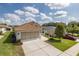Single-story home featuring a well-maintained lawn, long driveway, and an attached two-car garage at 284 Quane Ave, Spring Hill, FL 34609