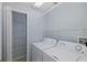 Bright laundry room features new appliances, shelving and tile flooring at 284 Quane Ave, Spring Hill, FL 34609