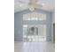 Spacious living room with tile flooring, ceiling fan, vaulted ceilings and sliding door entry to patio at 284 Quane Ave, Spring Hill, FL 34609