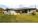 This home has lush backyard with a gray roof, neutral exterior, and black trimmed windows at 305 Yellow Elder, Punta Gorda, FL 33955