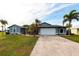 Charming single-story home with a well-manicured lawn and lush landscaping featuring palm trees at 305 Yellow Elder, Punta Gorda, FL 33955
