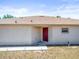 Rear exterior view showcasing a sturdy roof, minimal landscaping, and a traditional red door for a touch of color at 3885 Crossline Dr, Spring Hill, FL 34609