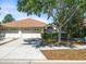 Charming home featuring a symmetrical front facade, attached two-car garage, and a mature shade tree in the front yard at 3885 Crossline Dr, Spring Hill, FL 34609