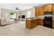 Open-concept kitchen with wooden cabinets and modern appliances next to the dining and living area at 4330 Crosswhite Ct, Spring Hill, FL 34609
