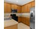 A kitchen shows wooden cabinets, stainless steel appliances, and tile flooring at 4330 Crosswhite Ct, Spring Hill, FL 34609