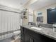 Modern bathroom featuring a shower with decorative curtain and a gray granite countertop at 4740 Tuscan Loon Dr, Tampa, FL 33619