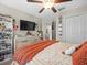 Bright bedroom featuring dual windows, custom decor and a ceiling fan and TV at 4740 Tuscan Loon Dr, Tampa, FL 33619