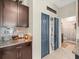 Hallway with access to a bathroom and storage, complemented by granite countertops and a cabinet at 4740 Tuscan Loon Dr, Tampa, FL 33619