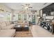 Well-lit living room with a spacious sectional sofa, ceiling fan, and access to a balcony at 4740 Tuscan Loon Dr, Tampa, FL 33619