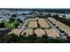 An aerial view of a residential neighborhood filled with yellow homes featuring red tile roofs and manicured landscaping at 4837 Rainbow Race, New Port Richey, FL 34652