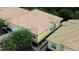 An aerial view of a yellow single-Gathering house with a tile roof, surrounded by greenery and a paved driveway at 4837 Rainbow Race, New Port Richey, FL 34652