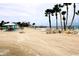 Expansive beach with chairs, palm trees, and ocean waters, offers a serene and picturesque setting at 4837 Rainbow Race, New Port Richey, FL 34652