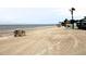 Scenic beach featuring palm trees, lounge chairs, and tranquil ocean waters for relaxation and enjoyment at 4837 Rainbow Race, New Port Richey, FL 34652