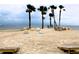 Picturesque beach scene with multiple cornhole boards, lounge chairs, palm trees, and calm ocean waters at 4837 Rainbow Race, New Port Richey, FL 34652