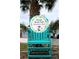 Private Beach Club sign on large Adirondack chair, surrounded by tropical palms and beautiful landscape at 4837 Rainbow Race, New Port Richey, FL 34652
