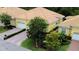 Exterior view of a yellow home showcasing a one car garage, paved driveway, and manicured lawn at 4837 Rainbow Race, New Port Richey, FL 34652