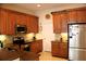 Well-lit kitchen with stainless steel appliances, granite counters, and wood cabinets, offering ample storage and prep space at 4837 Rainbow Race, New Port Richey, FL 34652