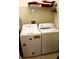 Laundry room features a full-size washer and dryer set with storage shelf above at 4837 Rainbow Race, New Port Richey, FL 34652