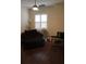 Living room features a comfortable lounge chair, ceiling fan, and window letting in natural light at 4837 Rainbow Race, New Port Richey, FL 34652