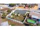Aerial shot showcasing a yellow house with fenced-in yard, patio area, tropical landscaping, and swimming pool at 4932 Gaslight Ave, Holiday, FL 34690