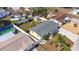 Aerial view of a yellow home featuring a fenced yard, well maintained landscaping, and an in-ground pool at 4932 Gaslight Ave, Holiday, FL 34690