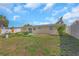 The backyard boasts green grass, mature landscaping, and a white fence line, offering a serene outdoor space at 4932 Gaslight Ave, Holiday, FL 34690