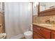 Cozy bathroom featuring a wood vanity, granite countertop, and tiled shower with a shower curtain at 4932 Gaslight Ave, Holiday, FL 34690