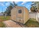 A quaint shed is nestled on a brick-paved area with tropical landscaping at 4932 Gaslight Ave, Holiday, FL 34690